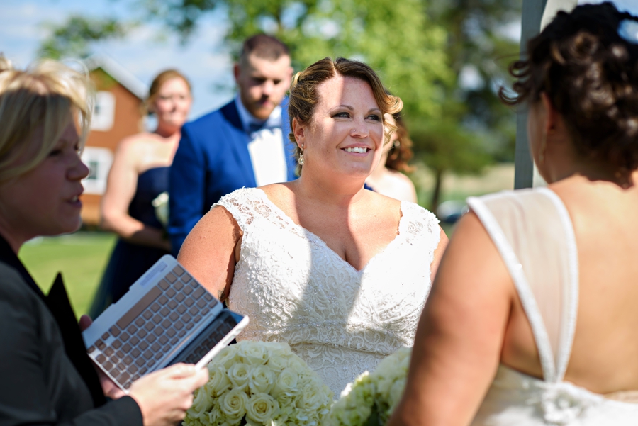 A bride smiling at her bride during her wedding.